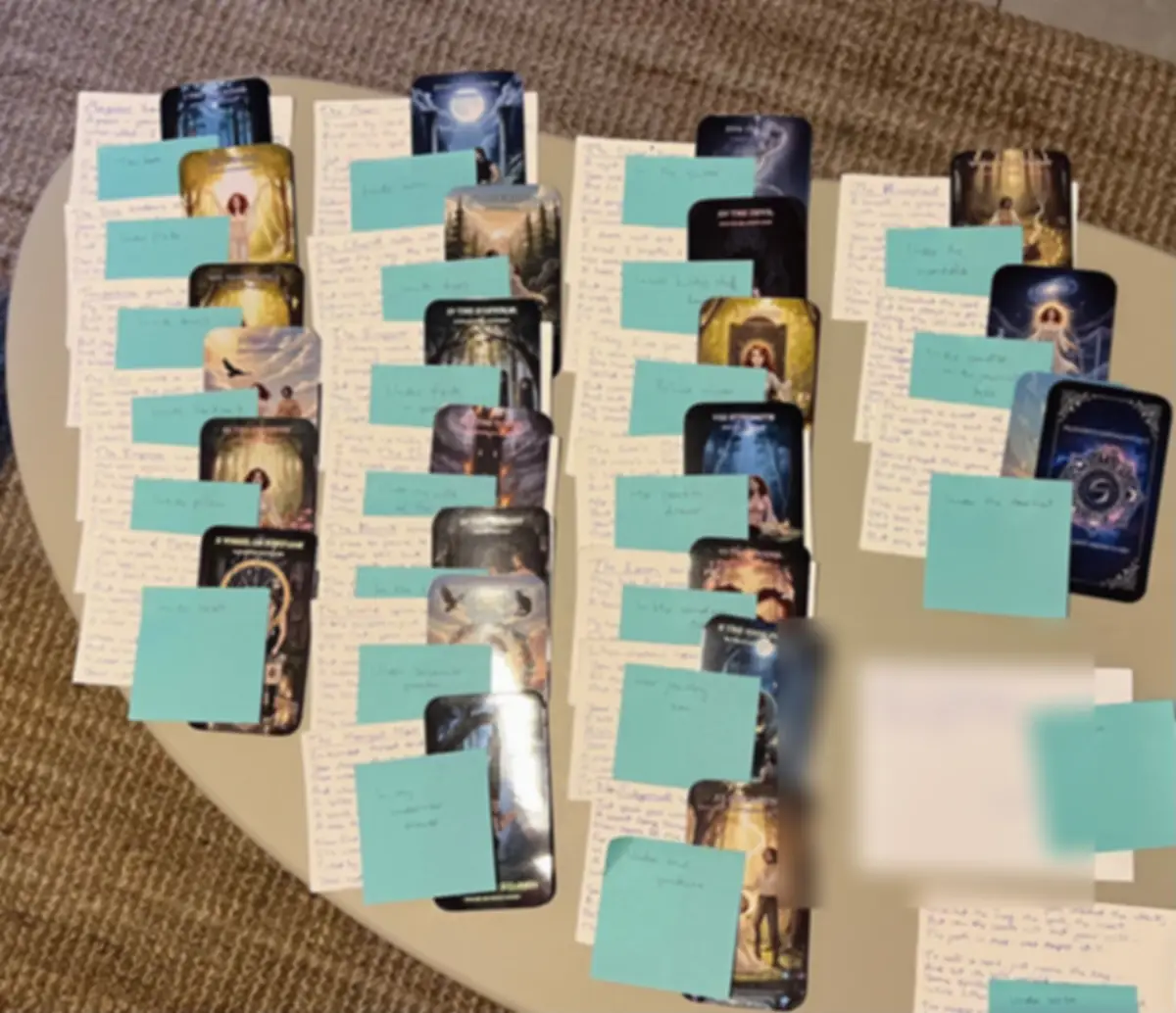 All 22 finished cards laid out on a table, each with a handwritten note and a sticky note naming its hiding place